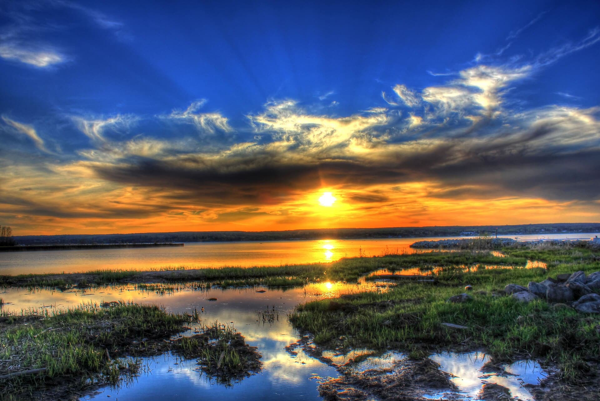 A Great Lakes sunset over water and marsh grass in Michigan.